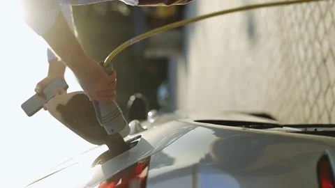 Vertical video of man plugging electric car from charging station. Male Stock Footage 200971915