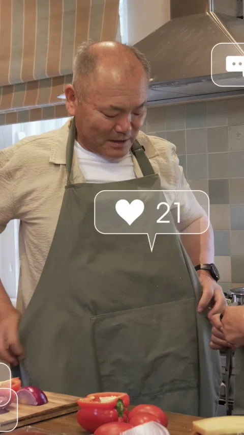 Vertical video: Man putting green apron on when woman holding strap, floating Stock Footage 333110165
