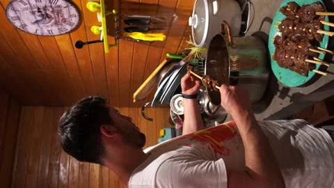 Vertical video of a man putting raw anticucho skewers on a seasoned wooden skewe Stock Footage 199514827