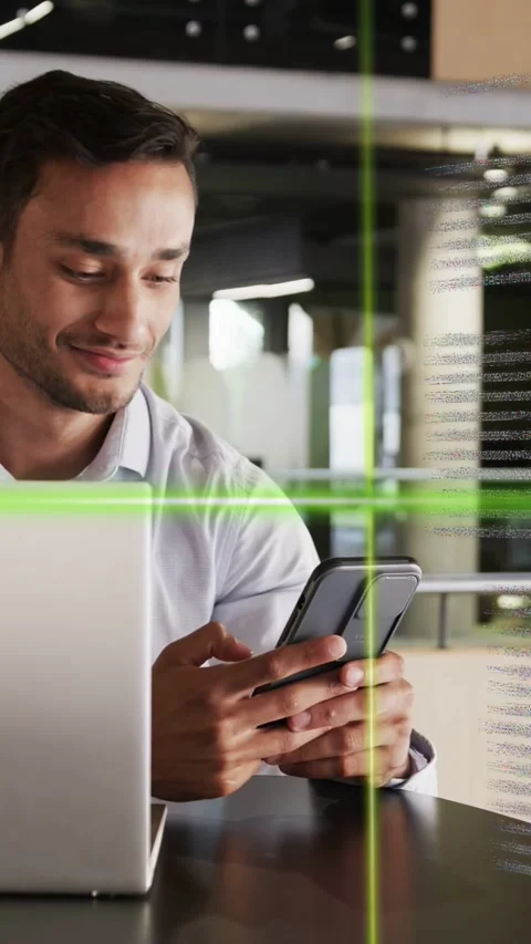 Vertical video: Man reaching for cell viewing data and toggling laptop in tech, Stock Footage 334704837