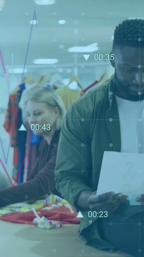 Vertical video: Man reading docs in fashion studio, data overlays rising over Stock Footage 337538887