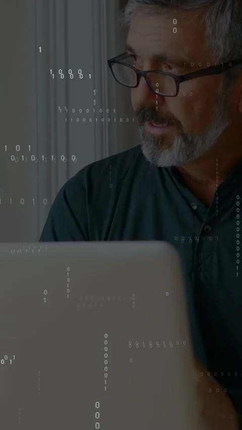 Vertical video: Man reading, fixing specs and typing laptop as binary overlay Stock Footage 332747722