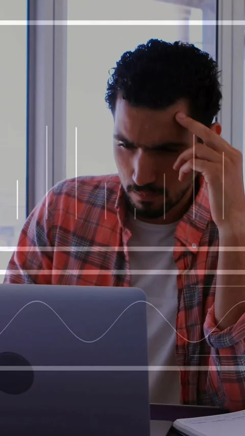 Vertical video: Man reading laptop screen, leaning forward, analyzing tech data Stock Footage 331580715