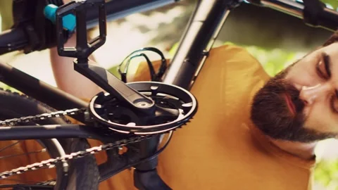 Vertical video Man realigning bicycle pedals in yard Stock Footage 248093849