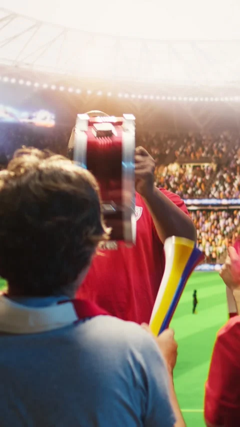 Vertical video Man in red soccer jersey uses drum to do team support during live Stock Footage 341679161