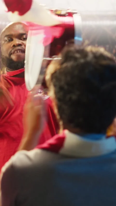 Vertical video Man in red soccer jersey uses drum to do team support during live Stock Footage 341679904