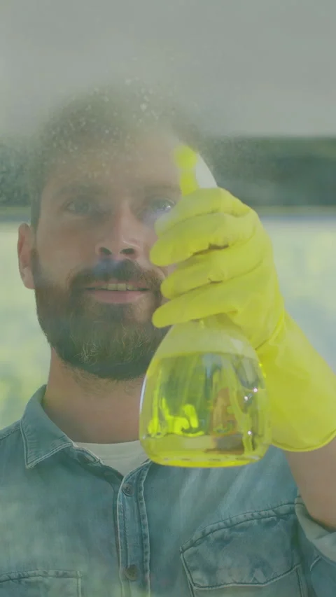 Vertical Video Man removing cleaning solution from glass with special tool Stock Footage 337994483