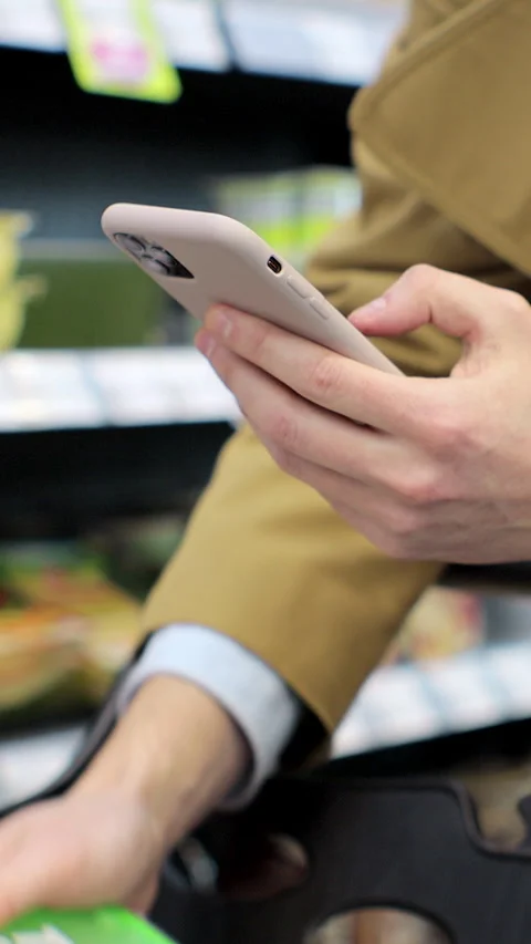 Vertical video. Man scanning product bar code in the shop using mobile phone app Stock Footage 346683887