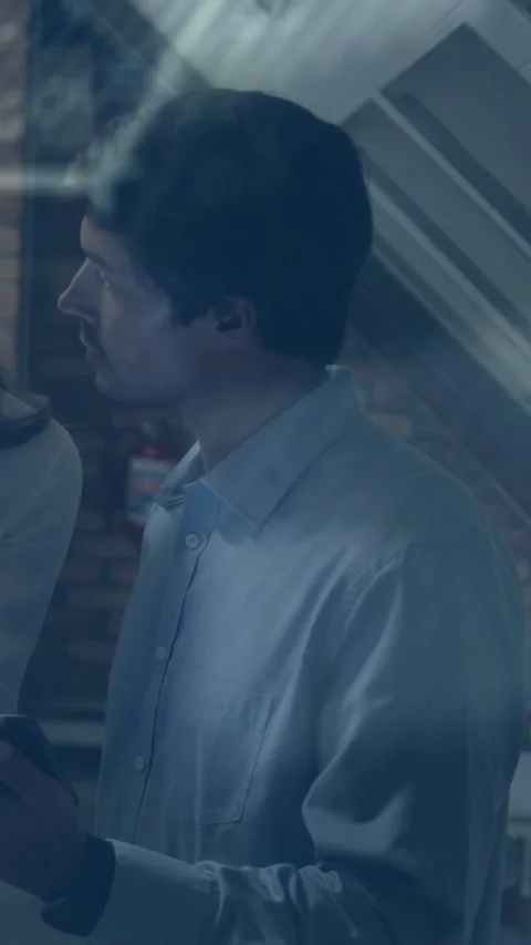 Vertical video: Man scrolling phone in loft, causing diagonal overlays guiding Stock Footage 333259510