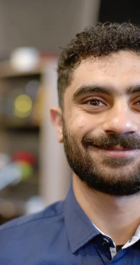 Vertical video: Man shifting neutral into smile while responding to camera in Stock Footage 339237049