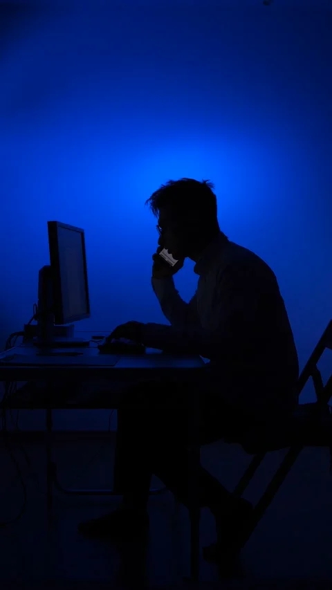 Vertical video Man silhouette working computer and talking on phone Stock Footage 318982866