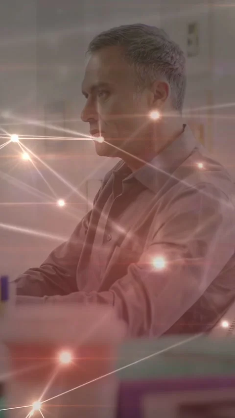 Vertical video: Man sitting at desk technology overlay appearing pulsing across Stock Footage 333821210