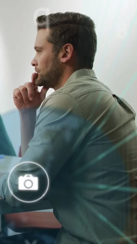 Vertical video: Man sitting desk thinking as onscreen net and mail icon emerging Stock Footage 334377808