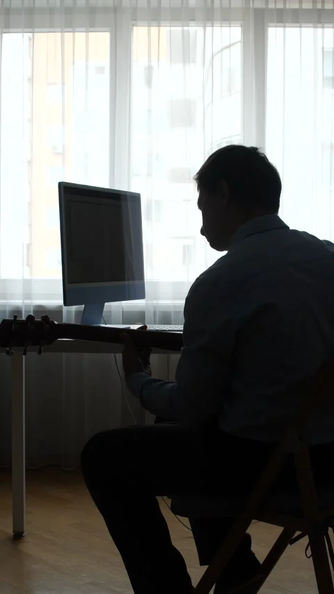 Vertical video man sitting at a desk and working on a desktop computer Stock Footage 345531242