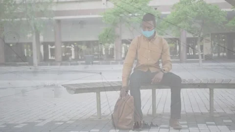 Vertical video: Man sitting plaza after ping, moving bag, checking time, tech Stock Footage 331108668