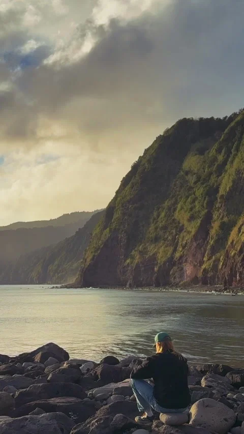 Vertical Video Man Sitting on Rocks, Ocean and Cliffs View, Azores São Miguel Stock Footage 316595406