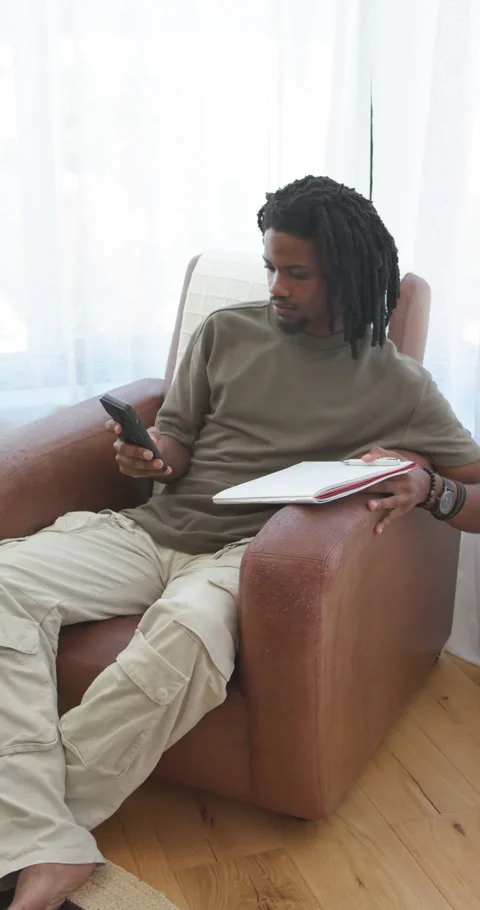 Vertical video: Man sitting in seat by window holding phone, scrolling texts and Stock Footage 345220096