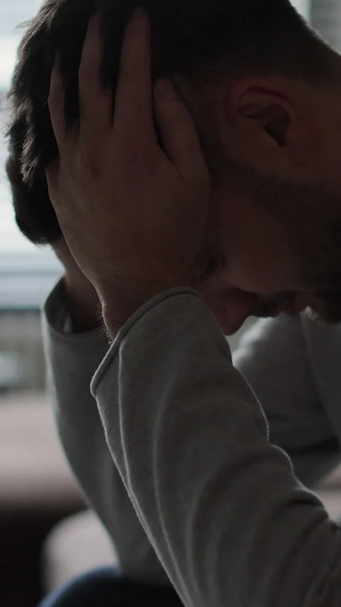 Vertical video Man sitting on sofa at home, unhappy upset thinking Stock Footage 337649301