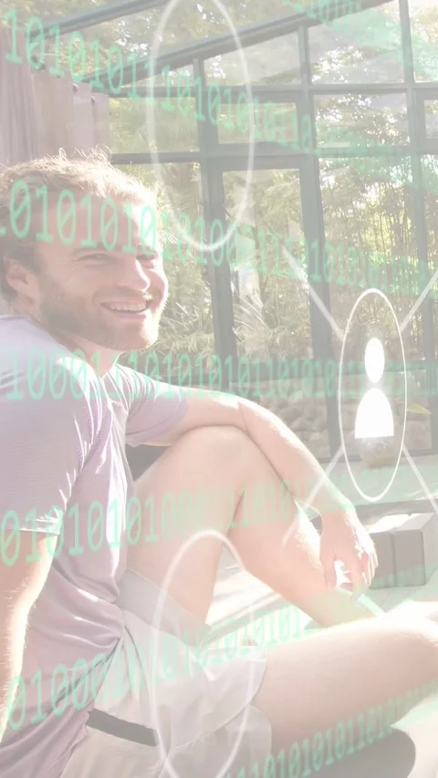 Vertical video: Man sitting in sunroom smiling as binary icons overlay aligning Stock Footage 333861899