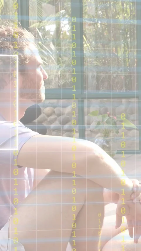 Vertical video: Man sitting by window moving hands making grid and bits layer Stock Footage 333021004