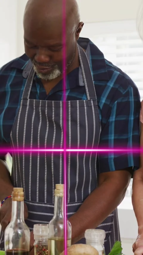Vertical video: Man smiling chopping and chatting in kitchen magenta overlays 库存影片 333541998