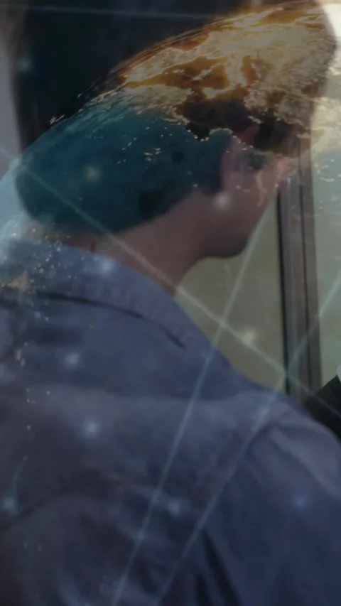 Vertical video: Man speaking by glass while technology globe overlay fading and Stock Footage 331047313