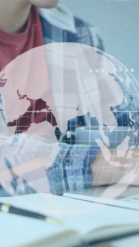 Vertical video: Man starting writing at desk, taking study notes, globe rotating Stock Footage 335355531