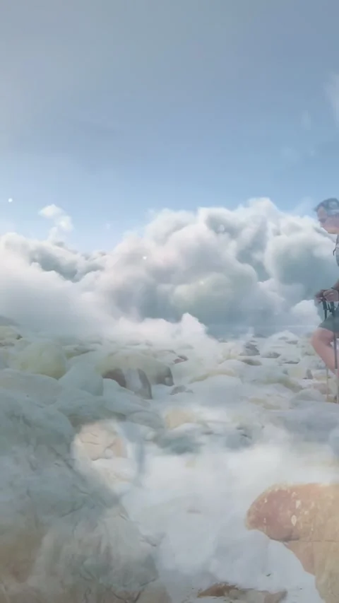 Vertical video: Man stepping ridge with poles while clouds rolling forward Stock Footage 332507123