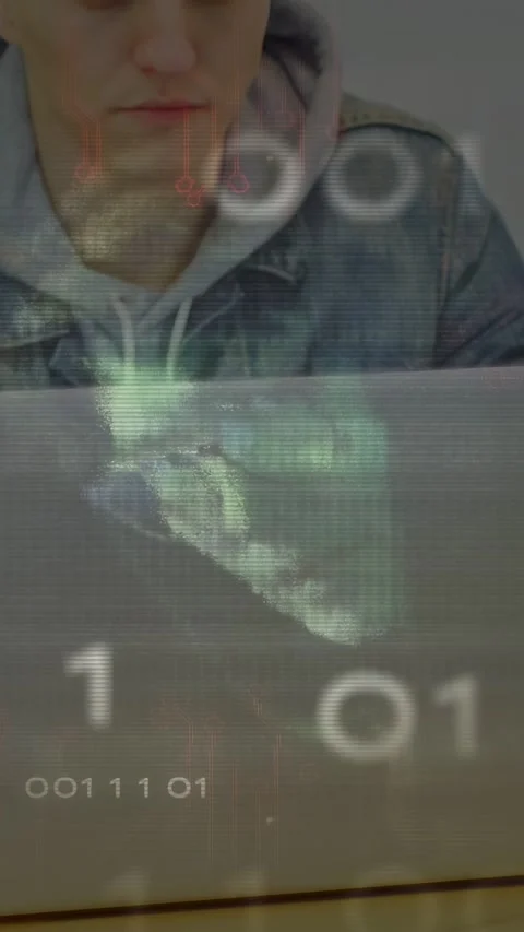 Vertical video: Man at table looking at laptop while binary bits brightening Video stock 332823290