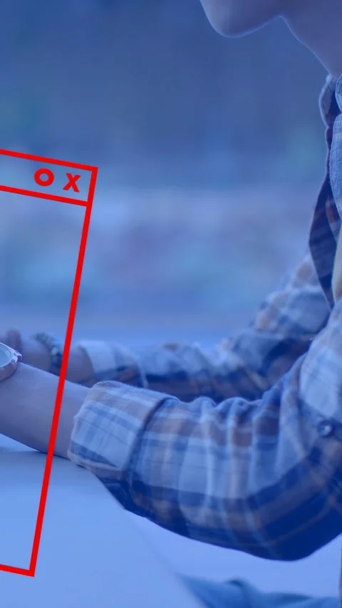 Vertical video: Man at table tapping device, causing red UI window forming Stock Footage 334770958