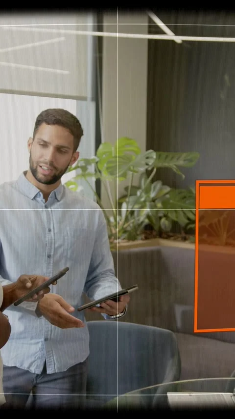 Vertical video: Man with tablet and phone, responding to taps, showing tech UI Stock Footage 333596043