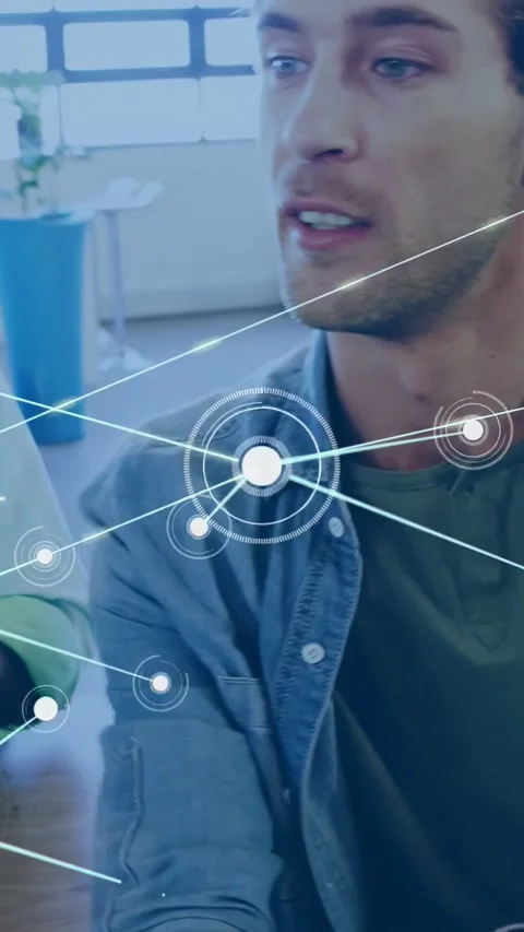Vertical video: Man with tablet tapping to activate HUD nodes linking laptop and Stock Footage 334549965