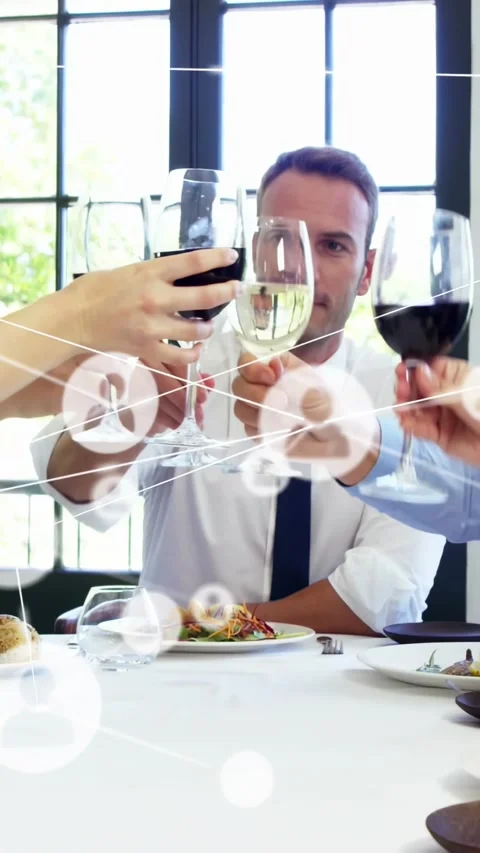 Vertical video: Man talking while team raising wine glasses causing icon overlay Stock Footage 334602377