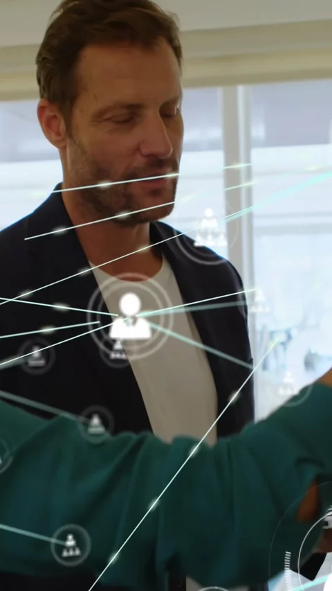 Vertical video: Man tapping laptop as coworker pointing, network nodes growing Stock Footage 332546693