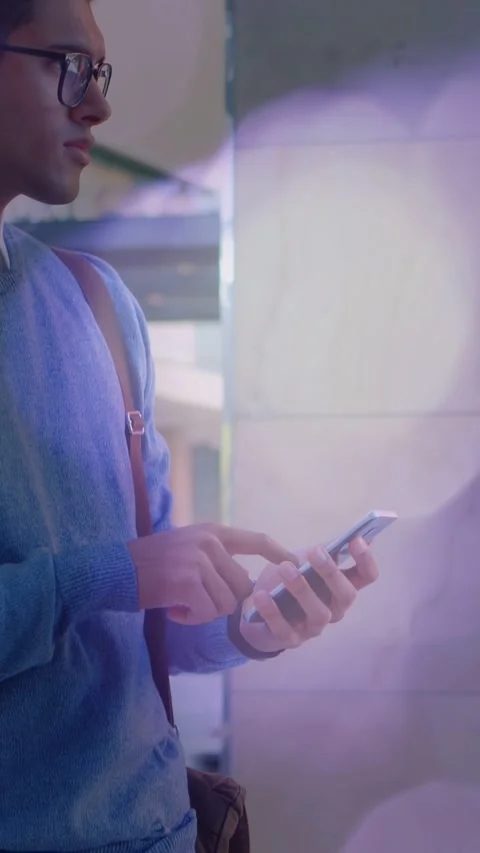 Vertical video: Man tapping phone, checking transit, camera pulling back left, Video stock 333821506