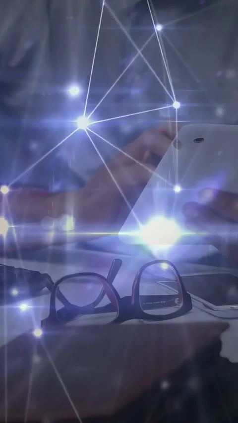 Vertical video: Man tapping phone by glasses on notebook testing tech while Stock Footage 334549793