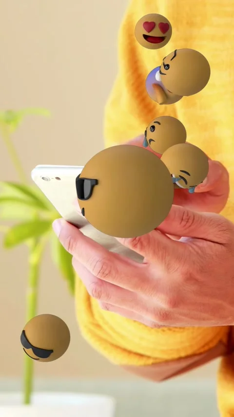 Vertical video: Man tapping phone, causing 3D emoji spheres filling frame and Stock Footage 335355553