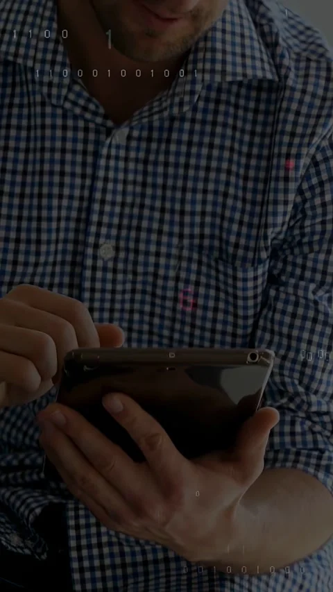 Vertical video: Man tapping, scrolling pad seeing tech code overlays growing on Stock Footage 331274378