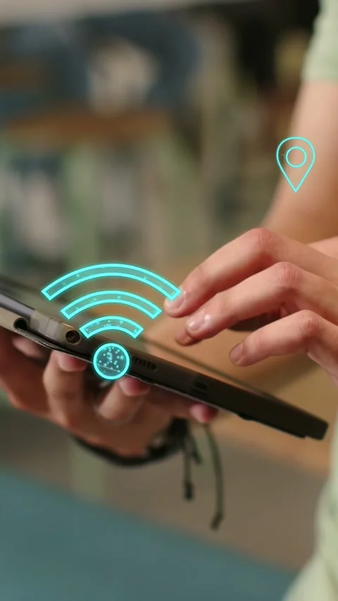 Vertical video: Man tapping tablet and swiping, testing pulsing WiFi and map-pin Stock Footage 334423485