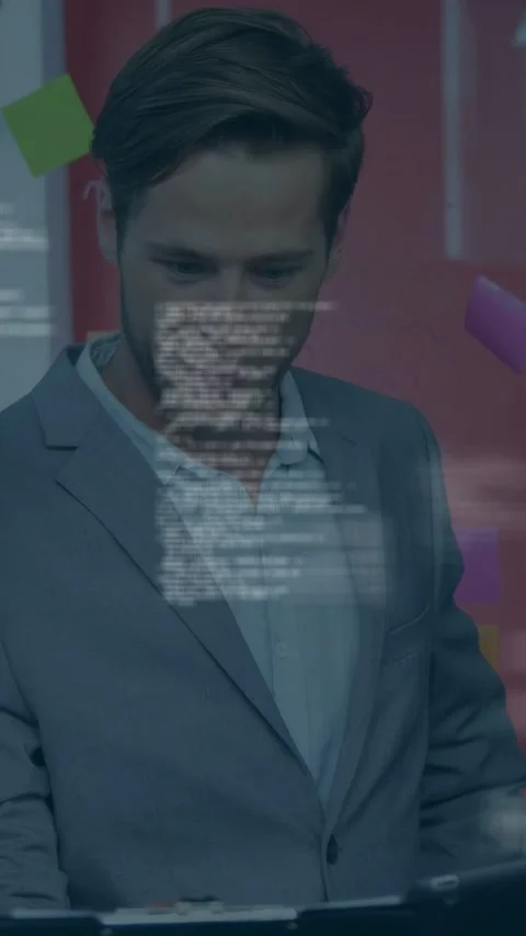Vertical video: Man tapping tablet at desk, floating code overlay showing Stock Footage 334792663
