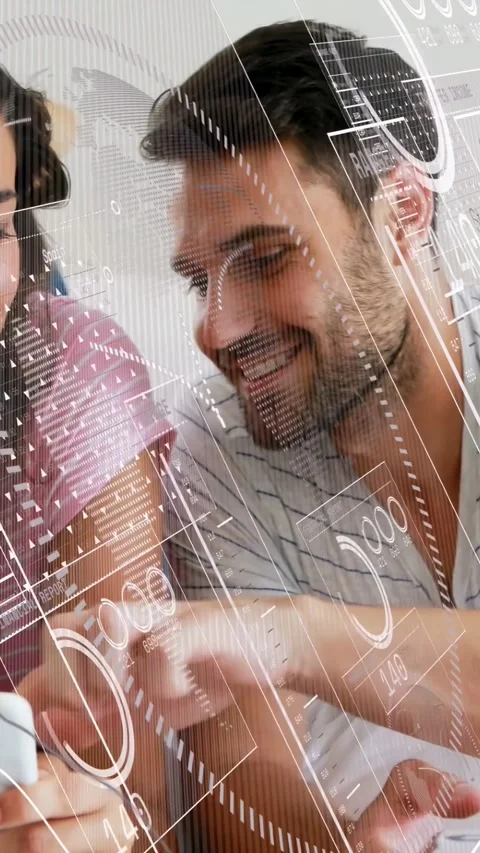 Vertical video: Man tapping woman's phone to share tech data, HUD charts sliding Stock Footage 333692132