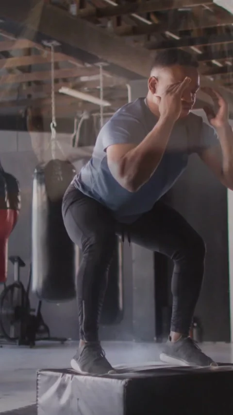 Vertical video: Man training lowering and swinging jumping onto plyo box Stock Footage 331790453