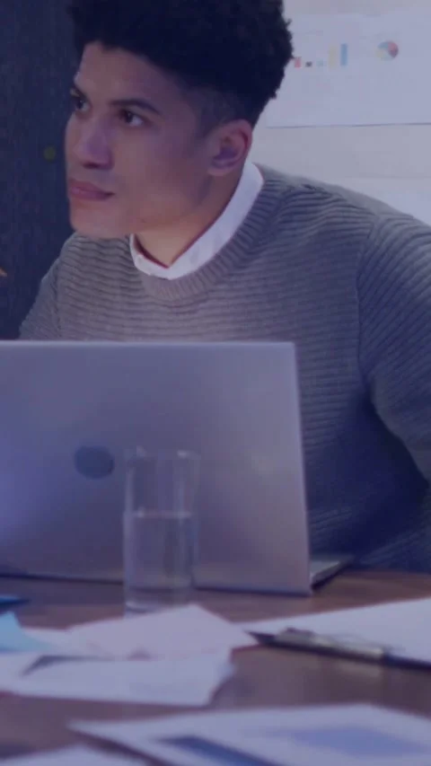 Vertical video: Man turning to host on slide, code overlay showing on laptop and Stock Footage 331739234