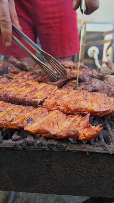 Vertical Video of Man Turning Mixed Meats on Charcoal Grill Today Stock Footage 346687208