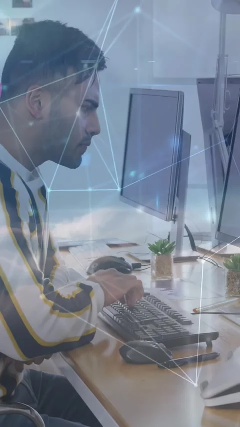 Vertical video: Man typing and clicking at two screens, pausing to study data, Stock Footage 332335343