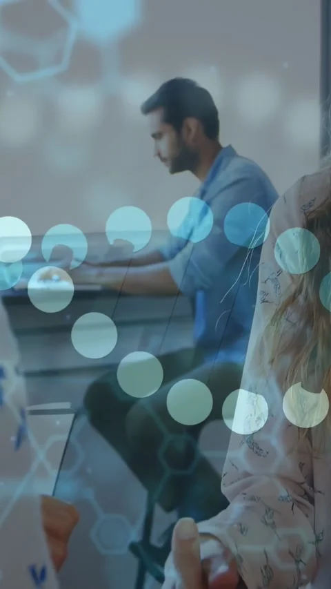 Vertical video: Man typing at desk, causing code overlays, hexagons and bokeh Stock Footage 334602449