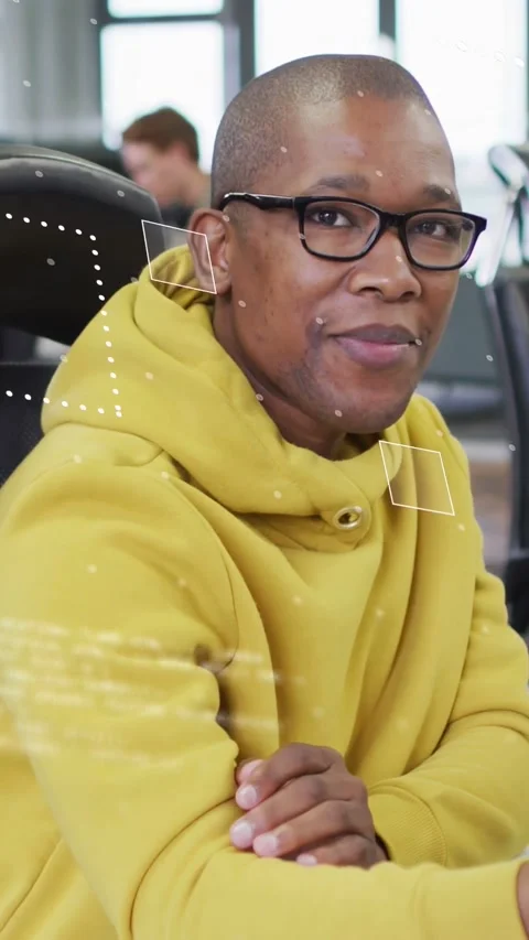 Vertical video: Man typing on keys in tech hub showing HUD data overlays and Stock Footage 333913182