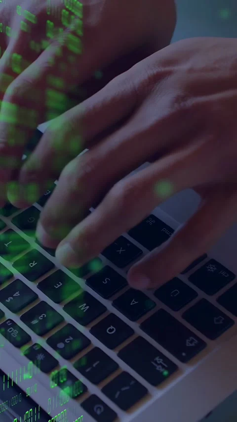 Vertical video: Man typing on keys, using trackpad, causing green code overlay Stock Footage 335741038