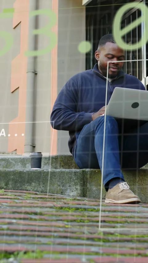 Vertical video: Man typing on laptop on steps, sparking green binary tech Stock Footage 332806857