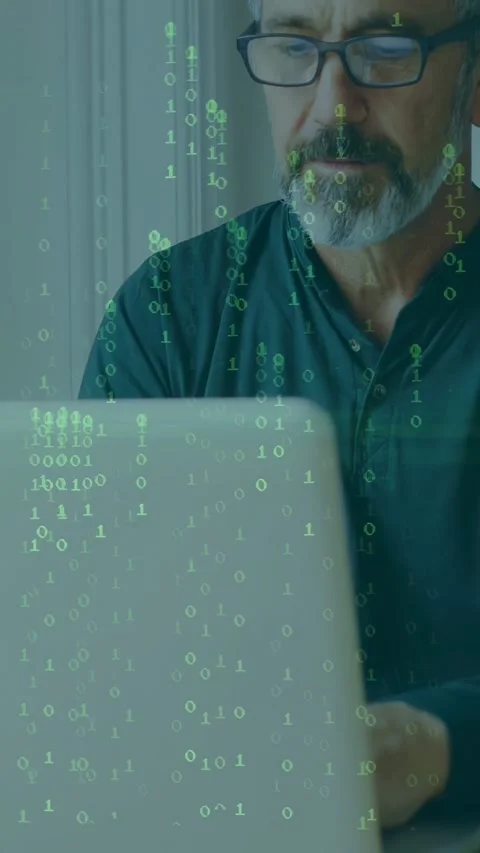 Vertical video: Man typing on laptop, causing green binary overlay and scanline Stock Footage 333235927